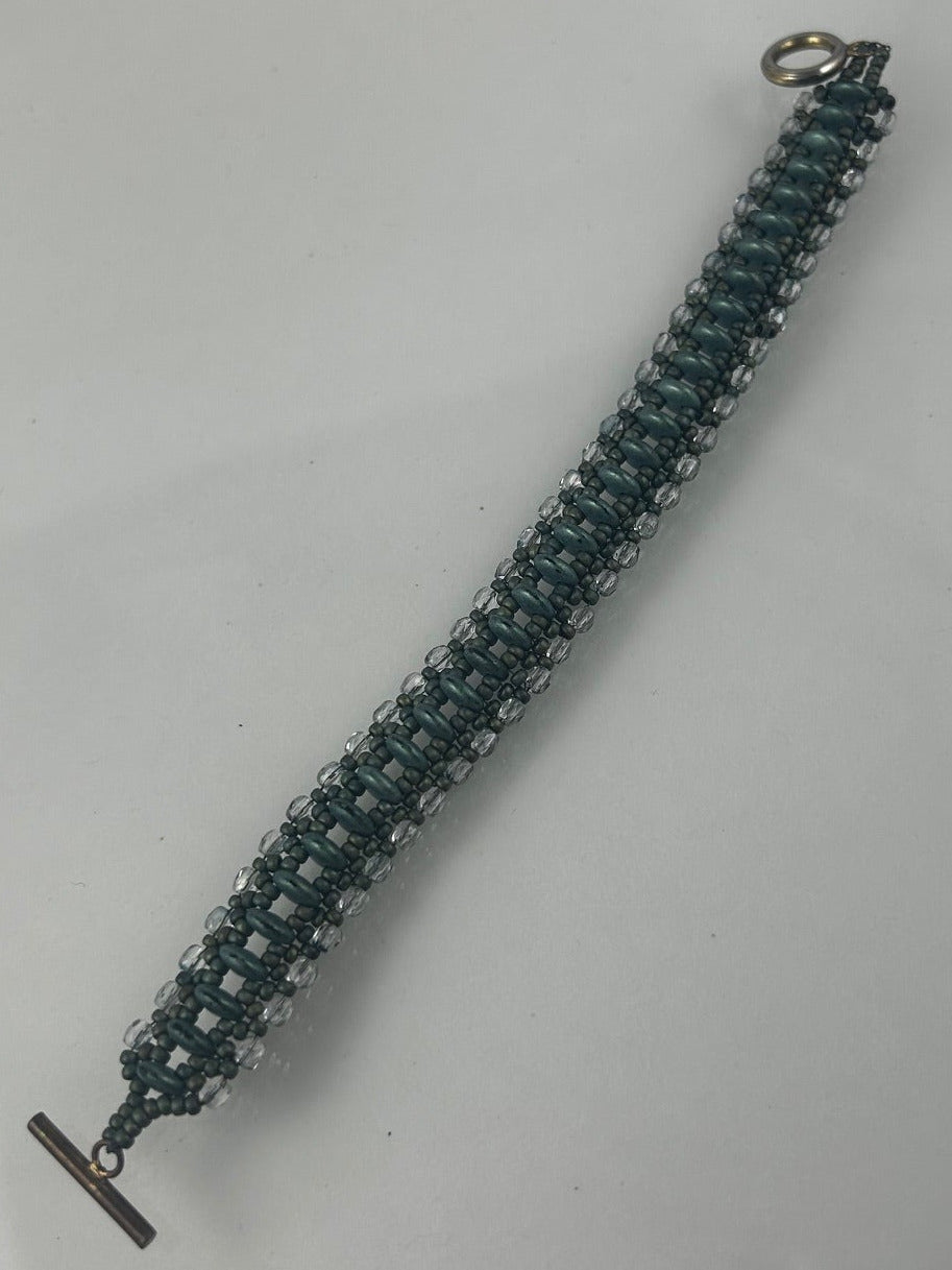 Roll along bracelet in green lentils and lt green crystals with silver toggle. $50.00